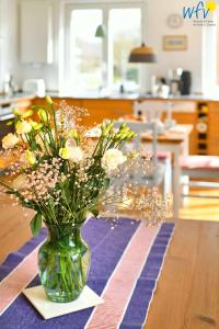 eine Vase voller Blumen auf einem Tisch in der Unterkunft Haus Skagen Ferienhaus Skagen Wangerooge in Wangerooge