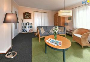 ein Wohnzimmer mit einem Sofa und einem Tisch in der Unterkunft Haus Skagen Ferienhaus Skagen Wangerooge in Wangerooge