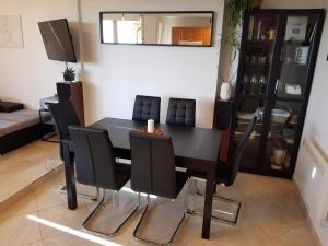 a dining room with a black table and chairs at Apartments with a parking space Umag - 22348 in Umag