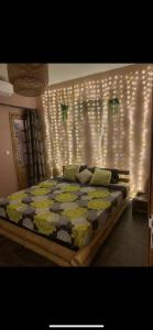 - une chambre dotée d'un lit avec des lumières sur le mur dans l'établissement Keur royal, à Dakar