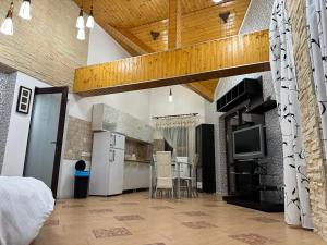 a kitchen with a refrigerator and a table with chairs at Heaven Apartment in Predeal