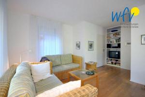 a living room with a couch and a table at Ferienhaus Friesenblick Ferienwohnung 2 in Wangerooge