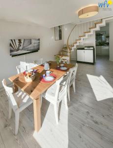 a dining room with a wooden table and white chairs at Fischerhus Ferienhaus Fischerhus Wangerooge in Wangerooge