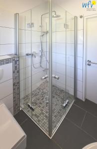 a shower with glass doors in a bathroom at Fischerhus Ferienhaus Fischerhus Wangerooge in Wangerooge +31 photos