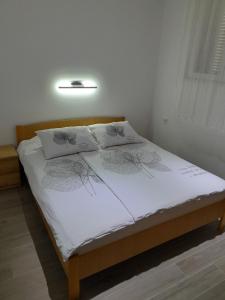 - un lit avec 2 oreillers dans l'établissement Apartments with a parking space Njivice, Krk - 22769, à Njivice