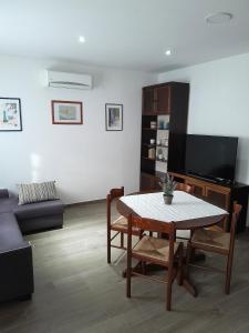 - un salon avec une table et une télévision dans l'établissement Apartments with a parking space Njivice, Krk - 22769, à Njivice