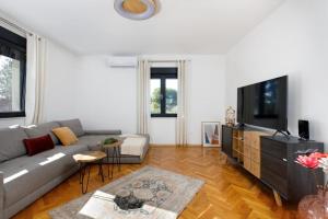 a living room with a couch and a flat screen tv at Holiday house with a parking space Drnis, Zagora - 22772 in Drniš