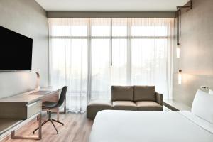um quarto de hotel com uma cama, uma secretária e um sofá em AC Hotel by Marriott Sunnyvale Moffett Park em Sunnyvale