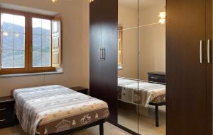 a bedroom with two beds and a glass closet at Amazing Home In Comano With Kitchenette in Comano