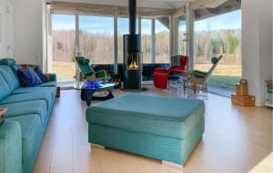 a living room with a blue couch and chairs at Lovely Home In Gustavsfors With Sauna in Gustavsfors