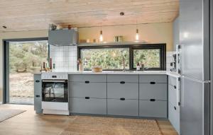 a kitchen with white cabinets and a refrigerator at Three-Bedroom Holiday Home In Jerup in Jerup +9 photos