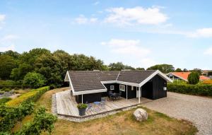 una pequeña casa negra con porche y terraza en 3 Bedroom Awesome Home In Broager, en Broager