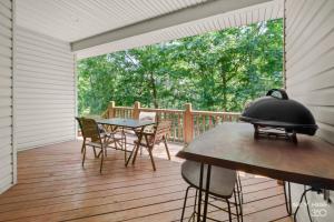 un porche cubierto con mesa y sillas en Relaxing BV Home near Golfing, Hiking, & Lakes, en Bella Vista
