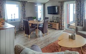 a living room with a table and chairs and a tv at Awesome Home In Rendalen With Kitchen in Rendalen