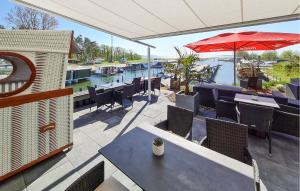 a patio with tables and chairs and an umbrella at Hausboot Hafensuite De Luxe in Sagard