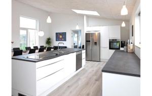 a kitchen with white cabinets and black counter tops at Amazing Home In Vejby With Kitchen in Vejby