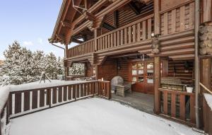a log cabin with snow on the porch at Nice Home In Vrådal With Kitchen in Vradal