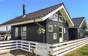 una casa negra con una cerca blanca delante de ella en Amazing Home In Nordborg With Wifi, en Nordborg