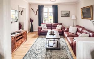 a living room with a leather couch and a coffee table at 5 Bedroom Lovely Home In Ruda in Ruda