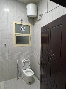 łazienka z toaletą, oknem i drzwiami w obiekcie Cozy Private Studio Apartment Near Airport w Abu Zabi