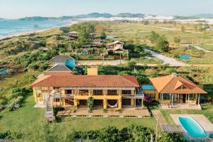 an aerial view of a house on a hill next to the ocean at Kahuma in Imbituba