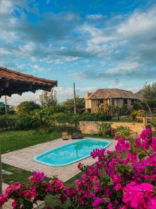 a swimming pool in a yard with flowers at Kahuma in Imbituba
