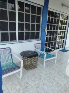 two chairs and a table in a room with windows at Las Palapas de Punta Allen in Punta Allen