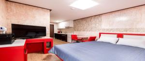 Yoninsan Spring Resort في كابيونغ: غرفة نوم بسرير كبير وتلفزيون بشاشة مسطحة