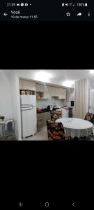 佩洛塔斯的住宿－Apto ao lado do Parque UNA，厨房配有白色冰箱、桌子和椅子