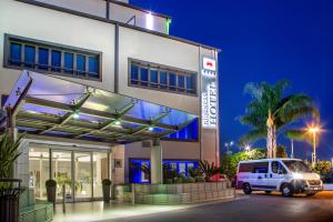 a white van parked outside of a building at night at Hotel Domidea in Rome