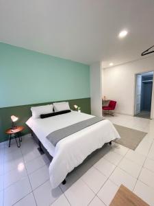 ein Schlafzimmer mit einem großen Bett und einer grünen Wand in der Unterkunft Nomadia Hostel Boutique in Bogotá