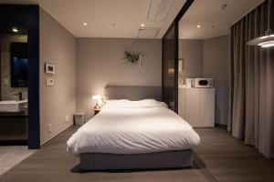 Un dormitorio con una cama grande y un baño. en Wecostay Namsan, en Seúl