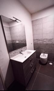 La salle de bains est pourvue d'un lavabo, d'un miroir et de toilettes. dans l'établissement Melting Pot Rome, à Rome