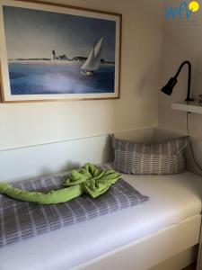 a bed with a green towel on top of it at Ferienhaus Seeblick Ferienwohnung 65 in Borkum