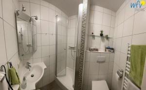 a bathroom with a shower toilet and a sink at Ferienhaus Seeblick Ferienwohnung 65 in Borkum +12 photos