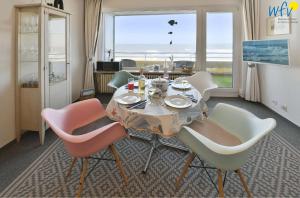 Un comedor con mesa y sillas y una ventana. en Dünenschlösschen Ferienwohnung 10, en Wangerooge