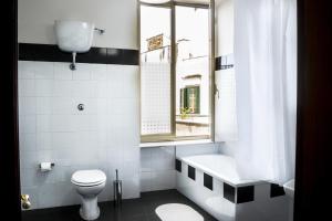 ein Badezimmer mit Badewanne, Toilette und Fenster in der Unterkunft Taggarb in Neapel + 35 Fotos