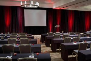 einen Konferenzraum mit Tischen, Stühlen und einem Bildschirm in der Unterkunft San Antonio Marriott Northwest Medical Center in San Antonio