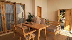 a dining room with a wooden table and a couch at Akasha Beach Club in Bulukumba