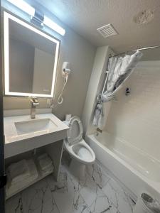 a bathroom with a sink and a toilet and a mirror at THE GOLFERS INN in Upper Darby