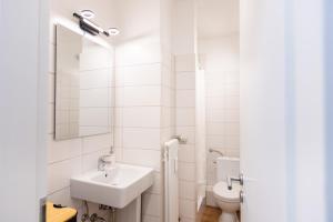 a white bathroom with a sink and a toilet at CARICASA: Bielefeld Mitte in Bielefeld