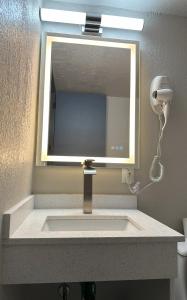 a bathroom sink with a mirror and a hair dryer at THE GOLFERS INN in Upper Darby