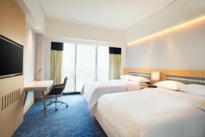 Una cama o camas en una habitación de Four Points by Sheraton Surabaya, Tunjungan Plaza