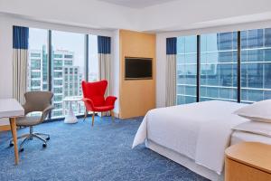 a hotel room with a bed and a desk and chairs at Four Points by Sheraton Surabaya, Tunjungan Plaza in Surabaya