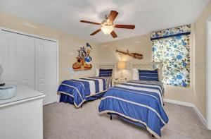 1 Schlafzimmer mit 2 Betten und einem Deckenventilator in der Unterkunft Elegant Lennar Free Water Park Resort in Kissimmee