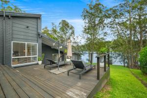a wooden deck with two chairs on it at Scenic 4-Bed Lake House 5-min Walk to Avoca Beach in Avoca Beach