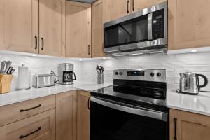 a kitchen with a black stove and a microwave at Powder Heights #21 townhouse in Sun Peaks