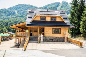 een houten huis met een gambrel dak bij Salaš Kľak in Fačkov