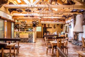 a restaurant with wooden ceilings and tables and chairs at Salaš Kľak in Fačkov