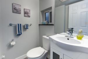 ein weißes Badezimmer mit Toilette und Waschbecken in der Unterkunft Suite Sunrise in Vancouver